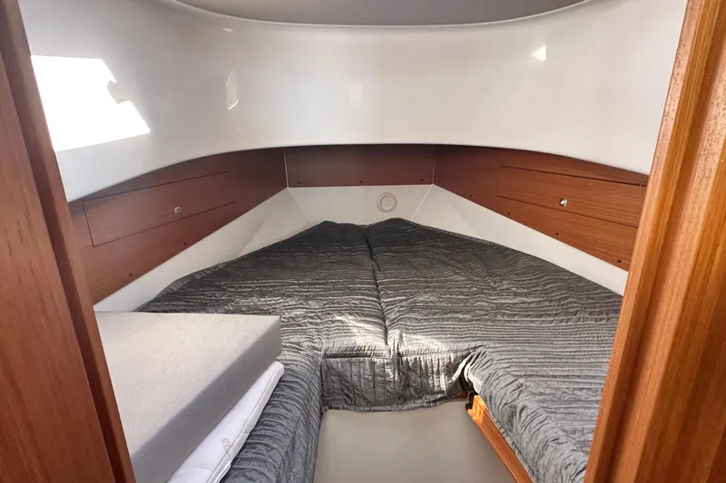 Slide: The Image of 2025 Sargo 31OB cabin interior with cozy bed and wooden accents. - 50