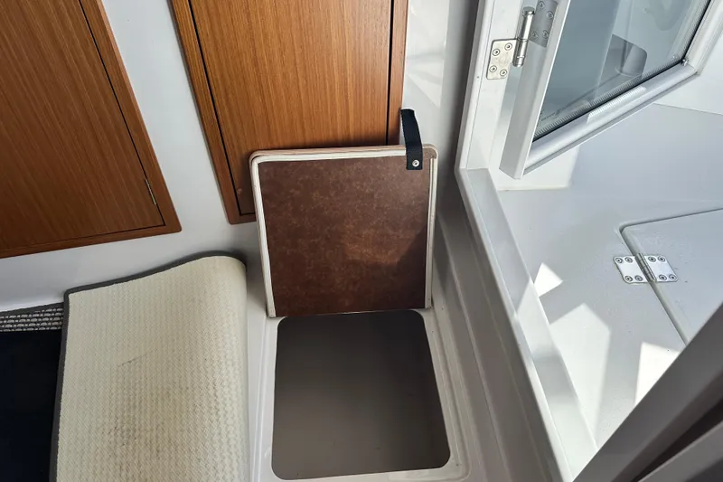 Slide: The Image of Interior of 2025 Sargo 31OB boat showing storage compartment and open window. - 51