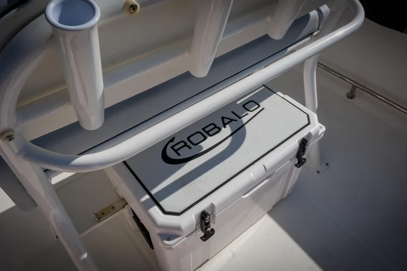 Slide: The Image of 2025 Robalo R230 Center Console boat interior with branded cooler and rod holders. - 11