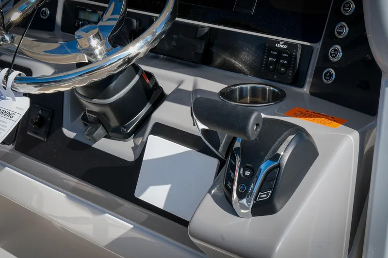 Slide: The Image of 2025 Robalo R230 Center Console boat dashboard with steering wheel and controls. - 12