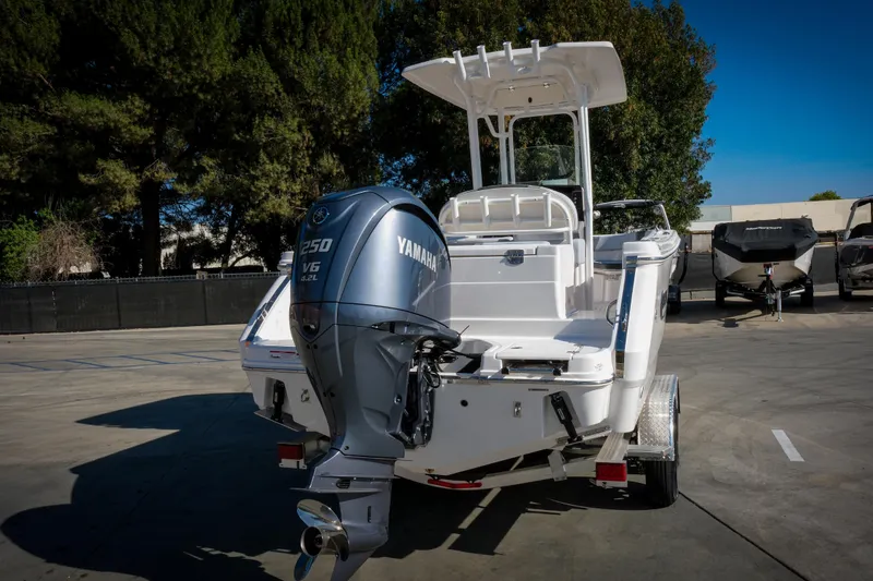 Slide: The Image of 2025 Robalo R230 Center Console boat with Yamaha V6 engine in a parking lot. - 16