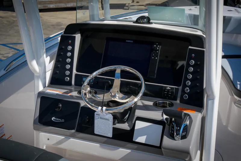 Slide: The Image of 2025 Robalo R230 Center Console boat dashboard with steering wheel and control panel. - 4