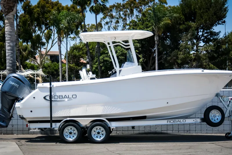 The Image of 2025 Robalo R230 Center Console boat on trailer, parked outdoors. - 1