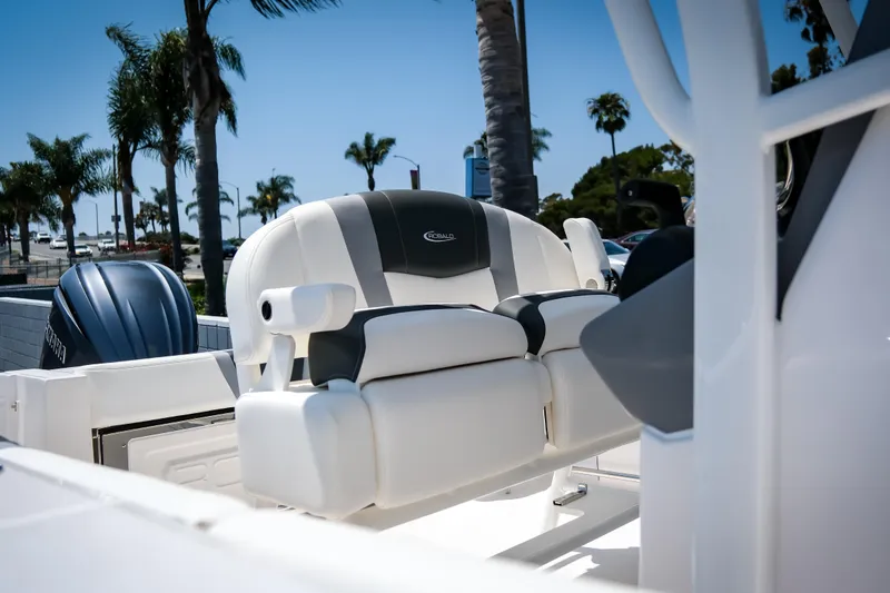 Slide: The Image of 2025 Robalo R230 Center Console boat interior with seating and palm trees in background. - 11