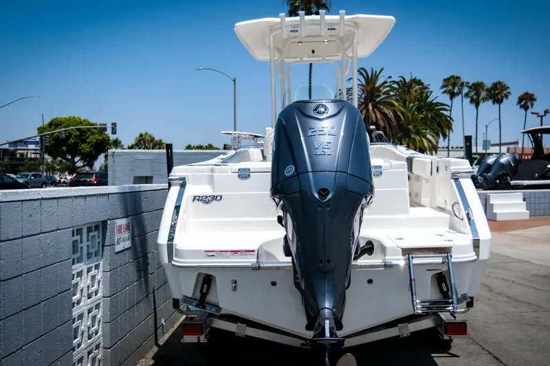 Slide: The Image of 2025 Robalo R230 Center Console boat with powerful outboard motor, parked outdoors. - 5