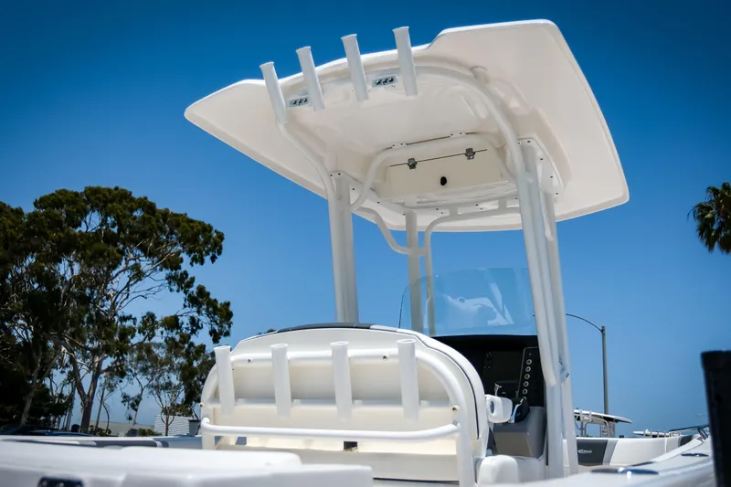 Slide: The Image of 2025 Robalo R230 Center Console boat with T-top against clear blue sky. - 6