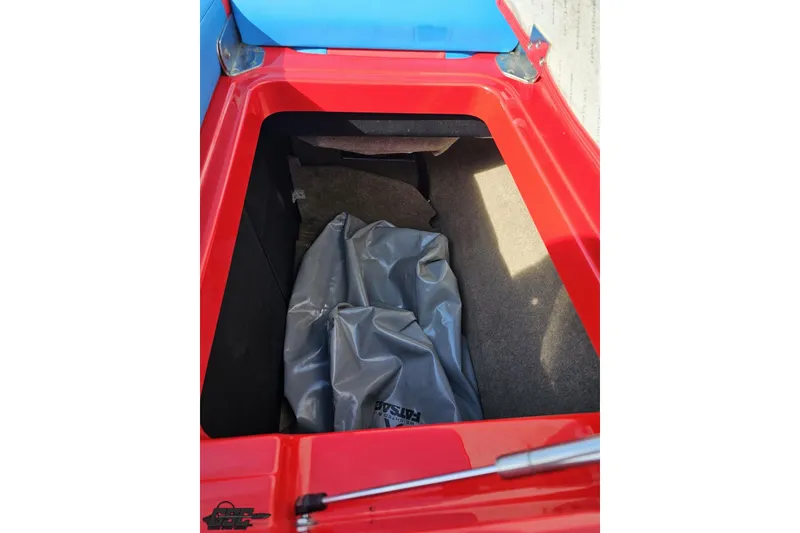 Slide: The Image of Open storage compartment of 2022 MasterCraft XT24 boat with red trim and gray interior. - 102