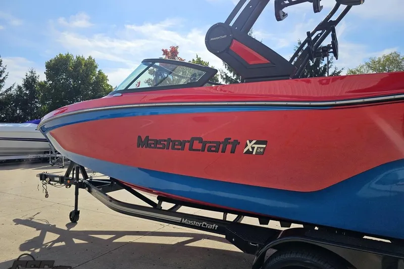 Slide: The Image of 2022 MasterCraft XT24 boat in vibrant red and blue on a trailer. - 23