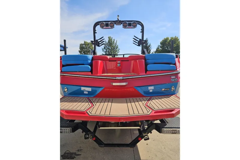 Slide: The Image of 2022 MasterCraft XT24 boat, red and blue, rear view with seating and speakers. - 28