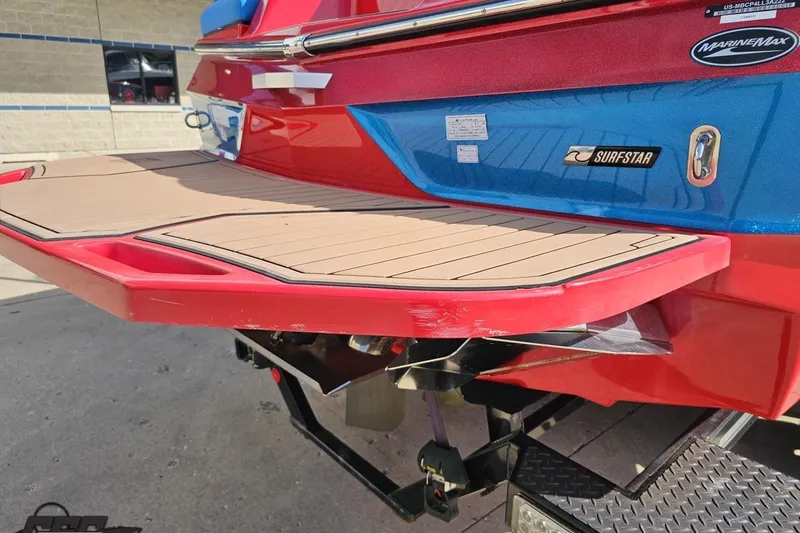 Slide: The Image of 2022 MasterCraft XT24 boat with red and blue exterior, featuring a teak swim platform. - 30