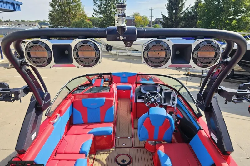 Slide: The Image of 2022 MasterCraft XT24 boat interior with red and blue seating, advanced sound system, and sleek dashboard. - 43