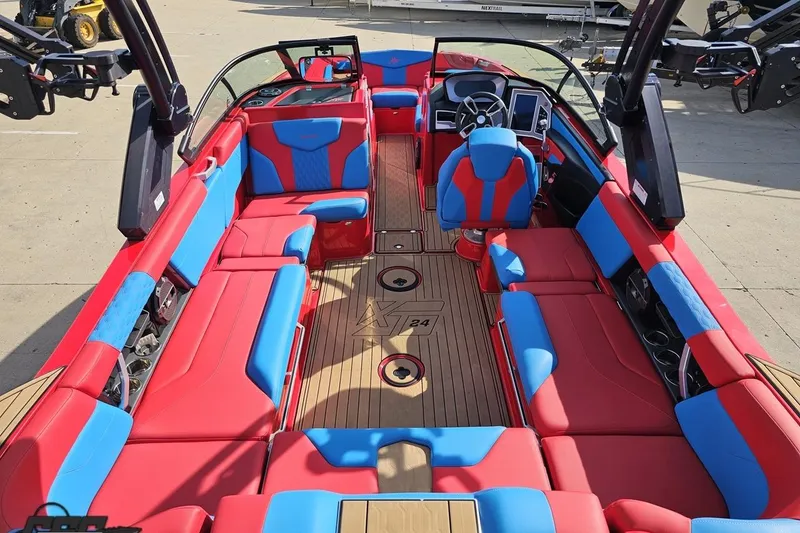 Slide: The Image of 2022 MasterCraft XT24 boat interior with red and blue seating, wooden flooring. - 44