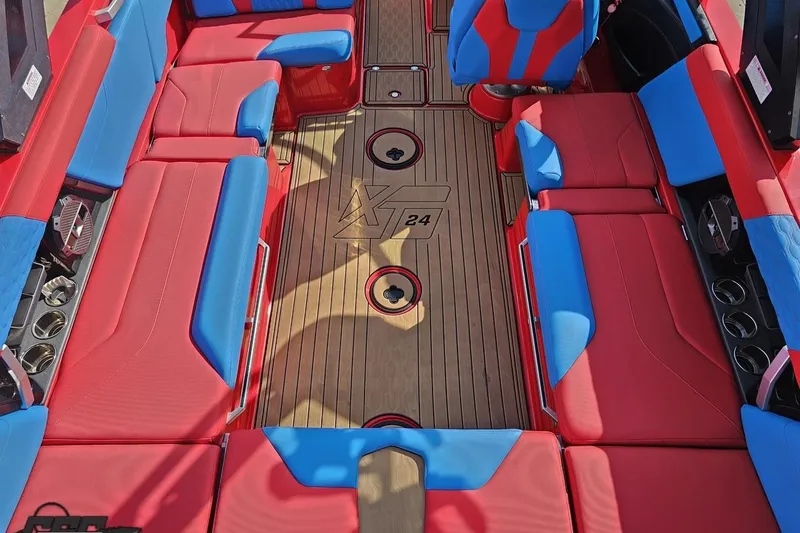 Slide: The Image of 2022 MasterCraft XT24 boat interior with red and blue seating, wood flooring. - 46