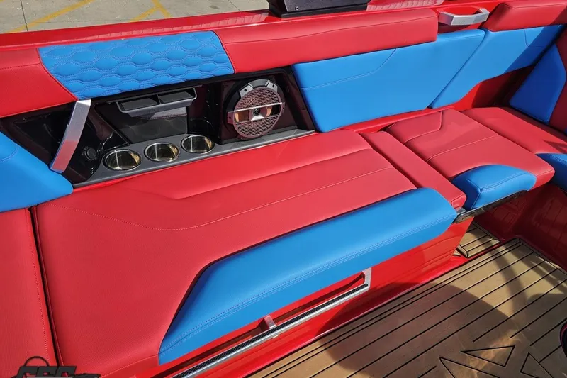 Slide: The Image of 2022 MasterCraft XT24 boat interior with red and blue seating, cup holders, and speaker. - 48