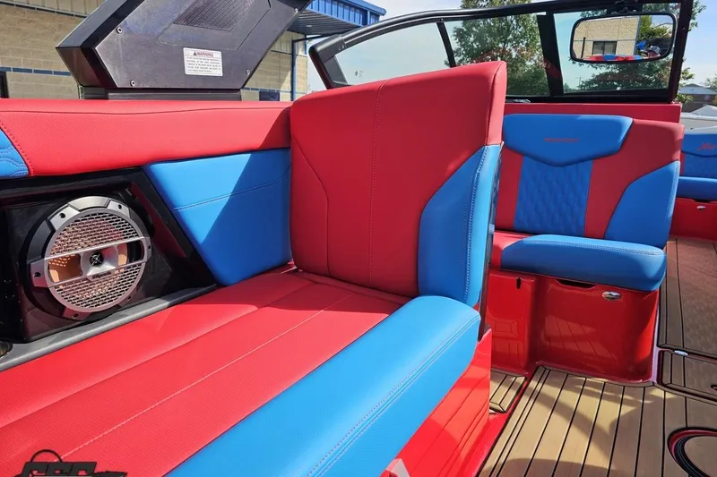 Slide: The Image of 2022 MasterCraft XT24 boat interior with red and blue seating and speaker system. - 51