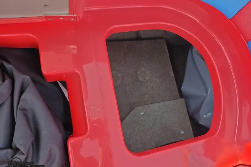 Slide: The Image of Red storage compartment in a 2022 MasterCraft XT24 boat, featuring carpeted interior. - 59