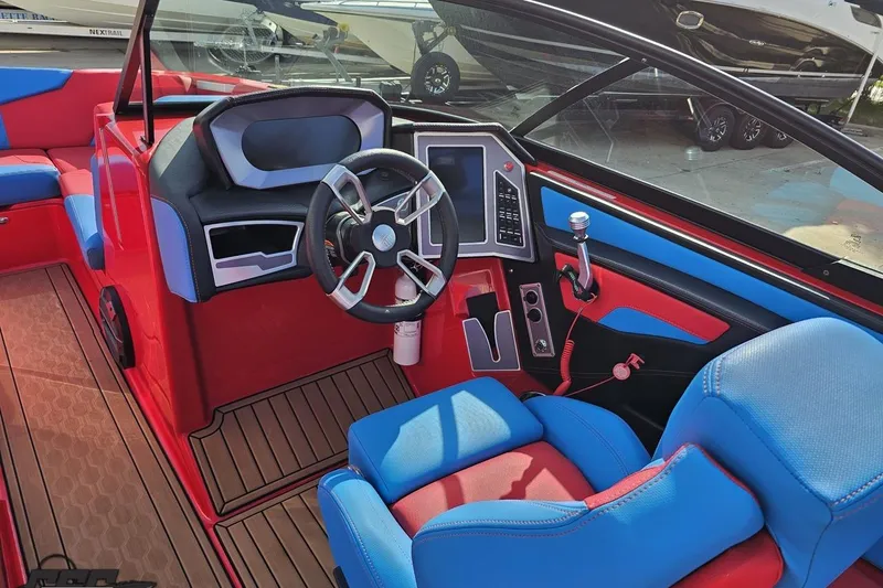 Slide: The Image of 2022 MasterCraft XT24 boat interior with vibrant red and blue seating and modern dashboard. - 62