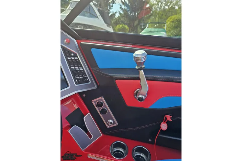 Slide: The Image of Interior of 2022 MasterCraft XT24 boat with vibrant red and blue accents. - 67