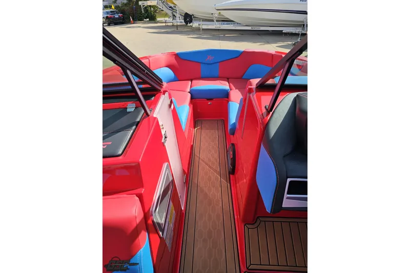 Slide: The Image of 2022 MasterCraft XT24 boat interior with red and blue seating, wooden flooring. - 75