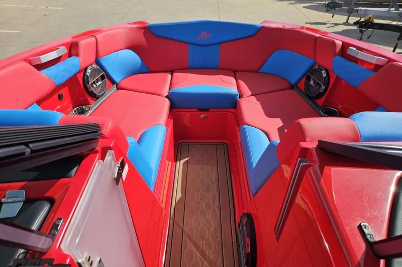 Slide: The Image of 2022 MasterCraft XT24 boat interior with vibrant red and blue seating. - 78