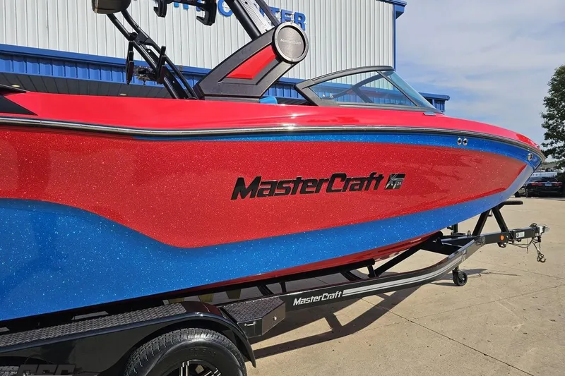 Slide: The Image of 2022 MasterCraft XT24 boat with red and blue exterior on a trailer. - 8