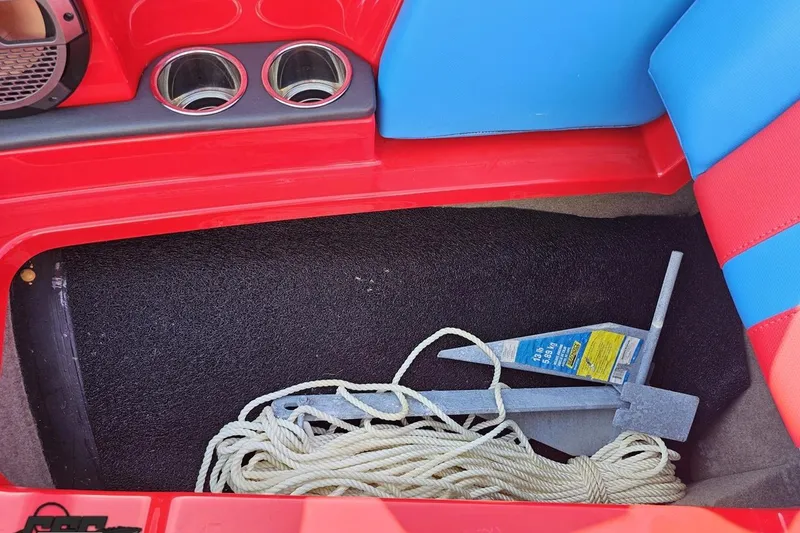 Slide: The Image of Red and blue interior of 2022 MasterCraft XT24 boat with anchor and rope storage. - 85
