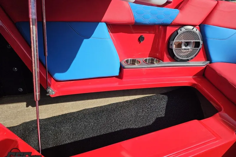 Slide: The Image of 2022 MasterCraft XT24 interior with red and blue seating, cup holders, and speaker. - 88