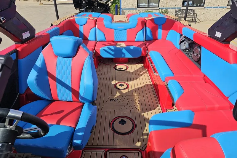 Slide: The Image of 2022 MasterCraft XT24 boat interior with vibrant red and blue seating. - 92