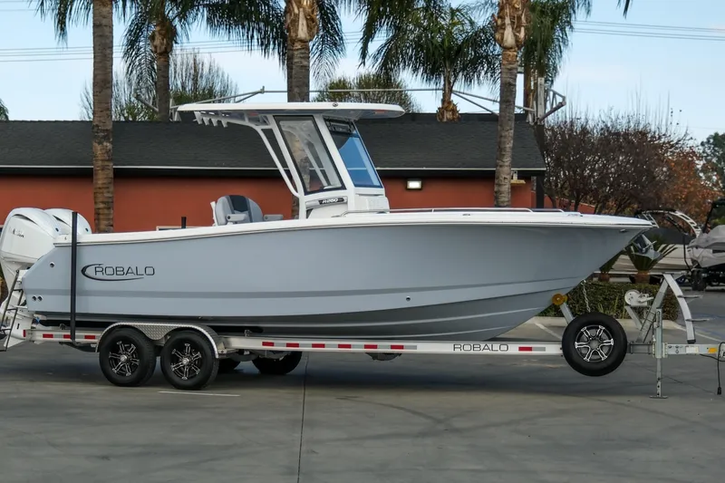 The Image of 2025 Robalo R250 Center Console boat on trailer, parked outdoors. - 1