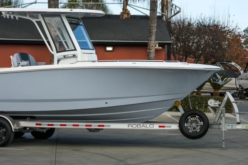 Slide: The Image of 2025 Robalo R250 Center Console boat on trailer, parked outdoors. - 3
