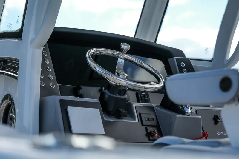 Slide: The Image of 2025 Robalo R250 Center Console boat dashboard with steering wheel and controls. - 6