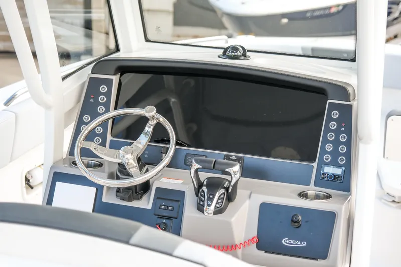 Slide: The Image of 2025 Robalo R250 Center Console boat dashboard with steering wheel and control panel. - 7
