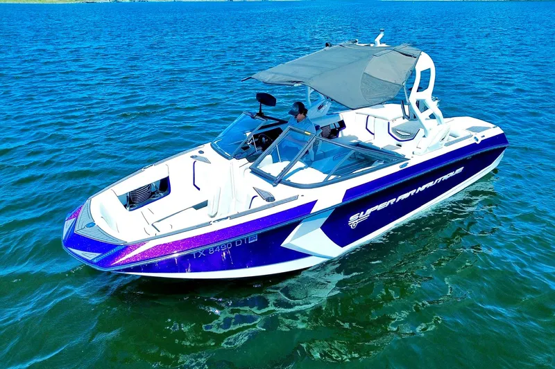 Slide: The Image of 2017 Nautique Super Air Nautique G23 boat on blue water, featuring sleek design and canopy. - 10