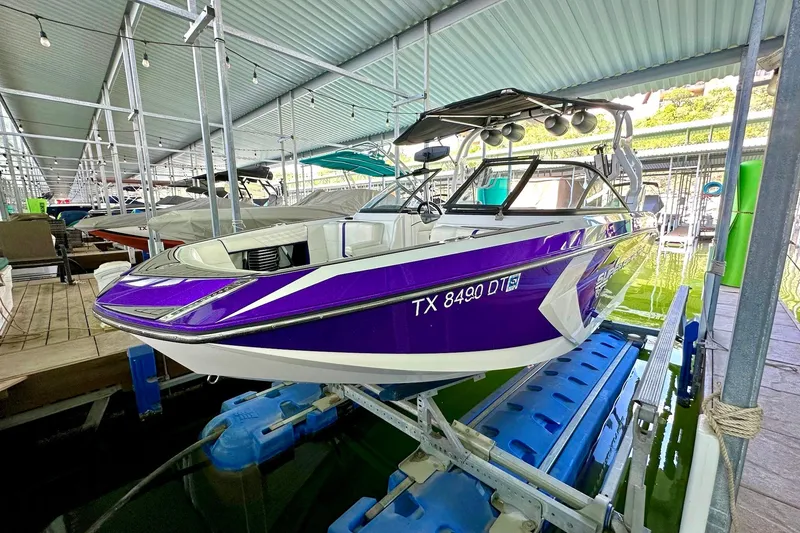 Slide: The Image of 2017 Nautique Super Air Nautique G23 boat in dock, vibrant purple and white design. - 14