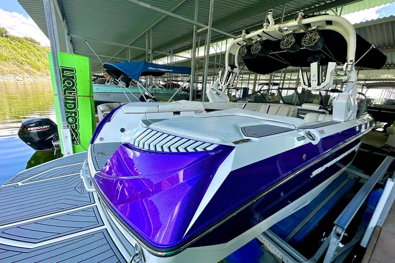Slide: The Image of 2017 Nautique Super Air Nautique G23 boat in dock, featuring vibrant purple detailing. - 16