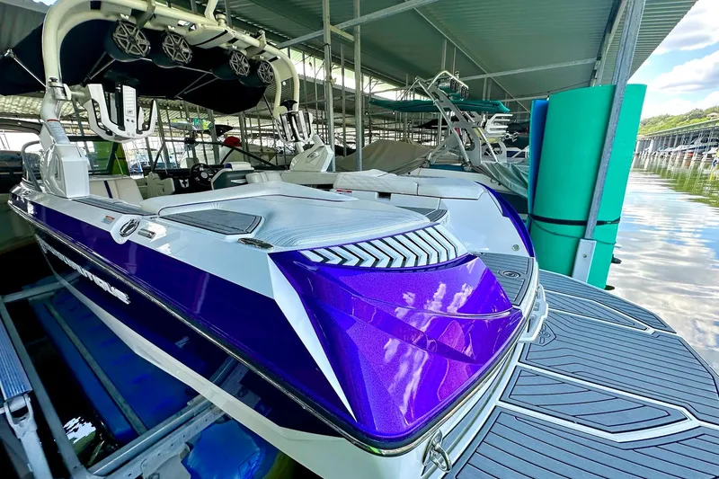 Slide: The Image of 2017 Nautique Super Air Nautique G23 boat docked, featuring sleek purple and white design. - 17