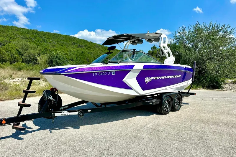 Slide: The Image of 2017 Nautique Super Air Nautique G23 boat on trailer, vibrant purple and white design. - 18