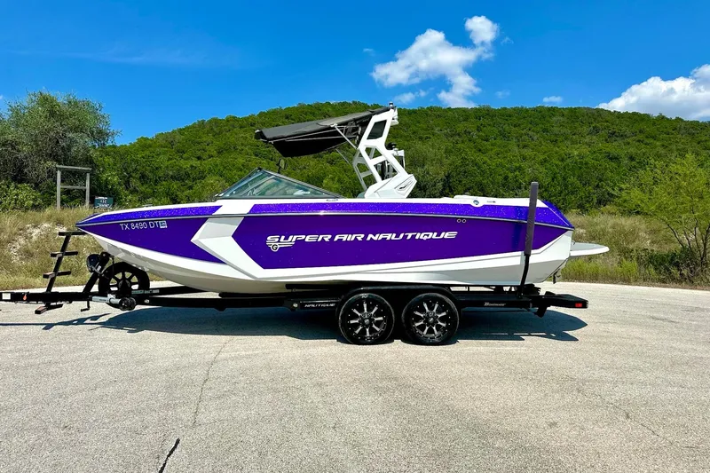 Slide: The Image of 2017 Nautique Super Air Nautique G23 boat on trailer, vibrant purple and white design. - 19