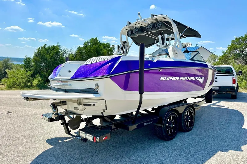 Slide: The Image of 2017 Nautique Super Air Nautique G23 boat on trailer, vibrant purple and white design. - 22