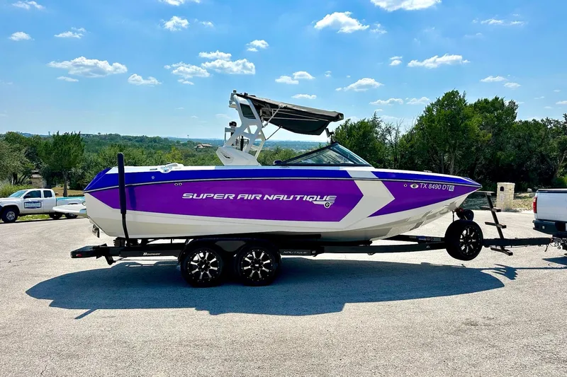 Slide: The Image of 2017 Nautique Super Air Nautique G23 boat on trailer, vibrant purple and white design. - 23