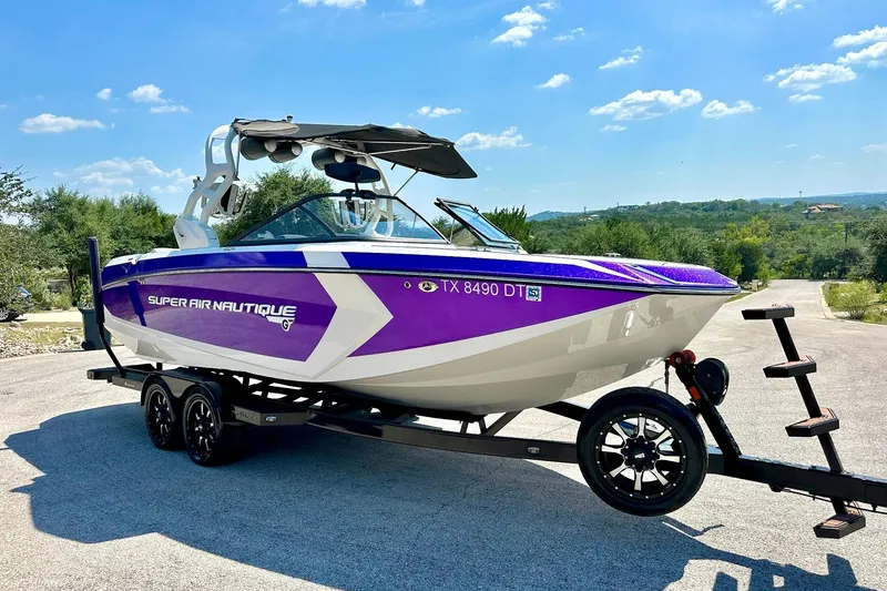 Slide: The Image of 2017 Nautique Super Air Nautique G23 boat on trailer, vibrant purple and white design. - 24