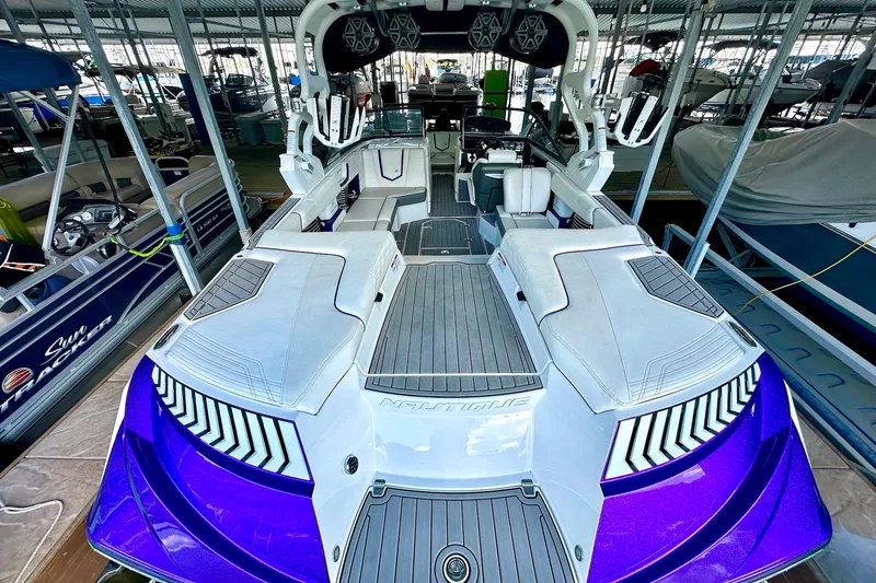 Slide: The Image of 2017 Nautique Super Air Nautique G23 boat with sleek design in a marina. - 26