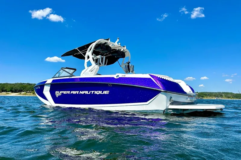 Slide: The Image of 2017 Nautique Super Air Nautique G23 boat on water under clear blue sky. - 3