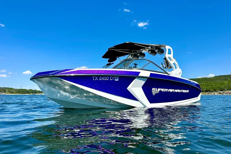 Slide: The Image of 2017 Nautique Super Air Nautique G23 boat on water, blue sky background. - 4
