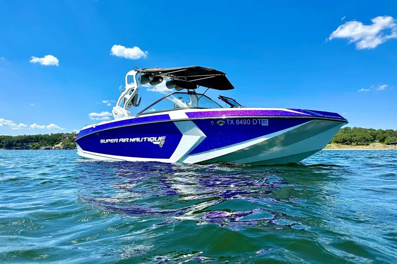 Slide: The Image of 2017 Nautique Super Air Nautique G23 boat on water under clear blue sky. - 7