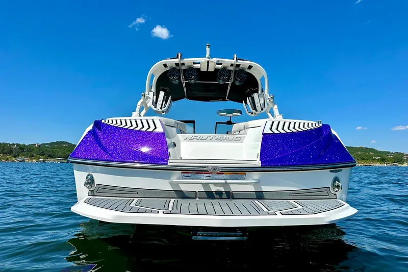 Slide: The Image of 2017 Nautique Super Air Nautique G23 boat on water, rear view, blue sky. - 8