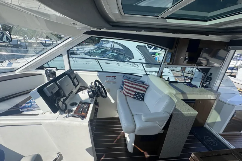 Slide: The Image of Interior of 2012 Cruisers Yachts 41 Cantius with helm, seating, and American flag pillow. - 18