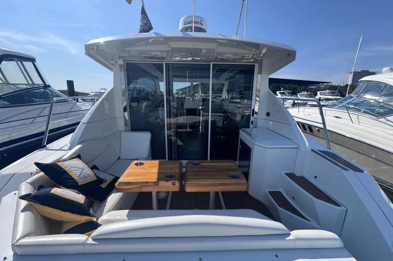 Slide: The Image of 2012 Cruisers Yachts 41 Cantius with outdoor seating and wooden tables, docked at marina. - 7