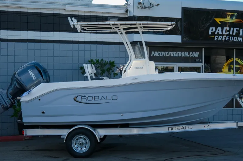 Slide: The Image of 2025 Robalo R180 Center Console boat on trailer, displayed outside dealership. - 3