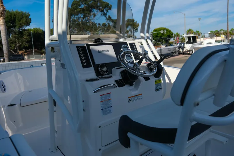 Slide: The Image of 2025 Robalo R180 Center Console boat interior with steering wheel and Simrad display. - 7